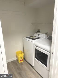 washroom featuring wood-type flooring and washing machine and clothes dryer