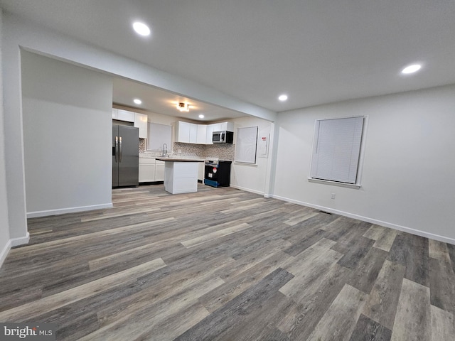 unfurnished living room featuring light wood-type flooring and sink