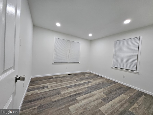 empty room with dark hardwood / wood-style flooring