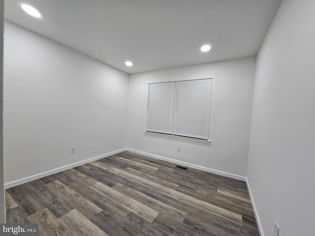 empty room with dark hardwood / wood-style flooring