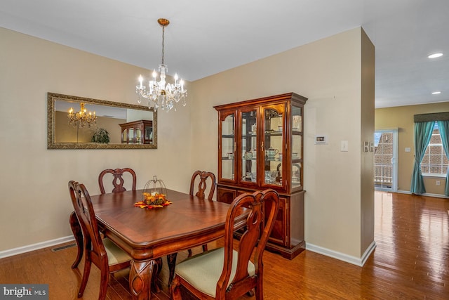 dining area with an inviting chandelier and hardwood / wood-style floors