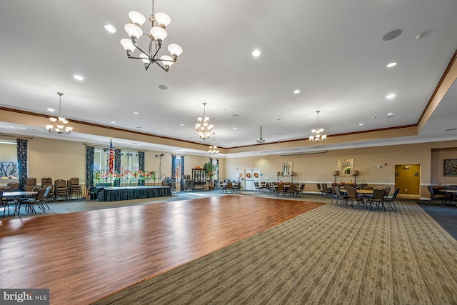 exercise room with crown molding, wood-type flooring, and a raised ceiling