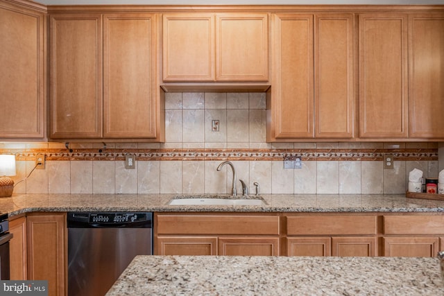 kitchen featuring dishwasher, tasteful backsplash, light stone countertops, and sink