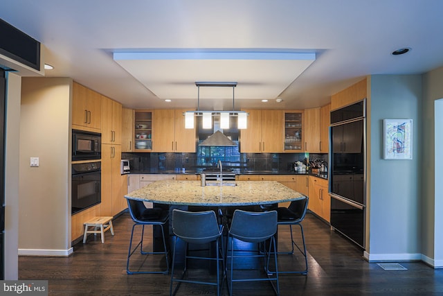 kitchen featuring dark hardwood / wood-style floors, light brown cabinets, black appliances, and decorative light fixtures