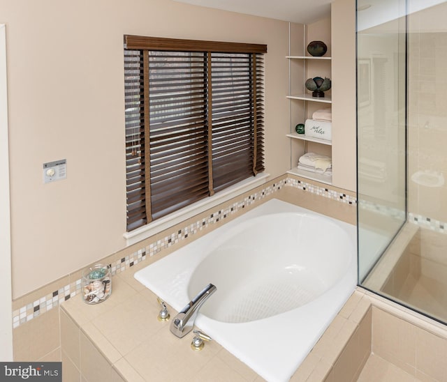 bathroom featuring tiled bath and built in features