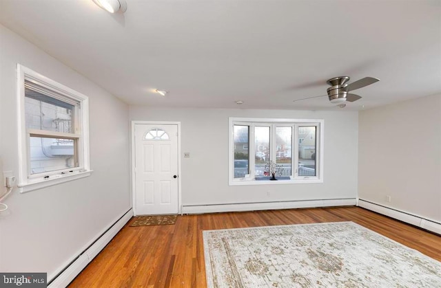 foyer entrance with ceiling fan, hardwood / wood-style flooring, and a baseboard heating unit