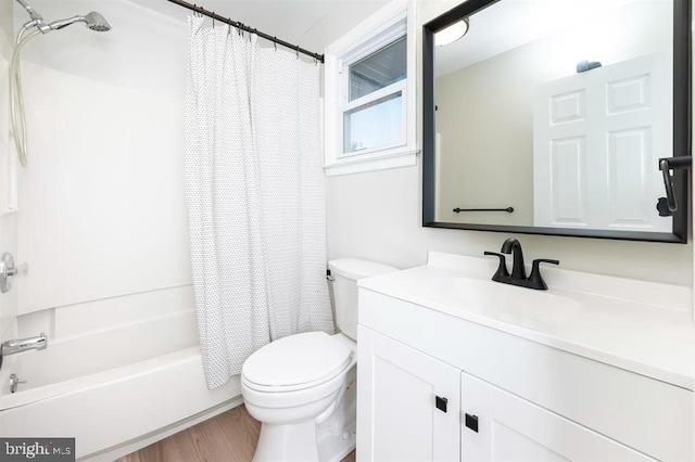 full bathroom featuring toilet, hardwood / wood-style floors, vanity, and shower / bath combination with curtain