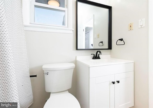 bathroom featuring toilet, curtained shower, and vanity