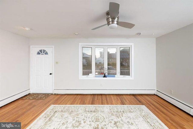 interior space with ceiling fan, baseboard heating, and hardwood / wood-style floors