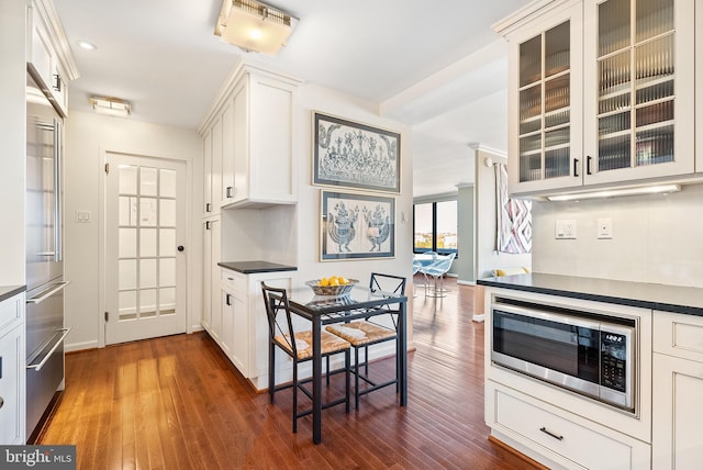 kitchen with built in appliances, white cabinets, and dark wood-type flooring