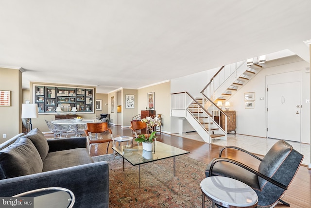 living room with ornamental molding and light hardwood / wood-style flooring