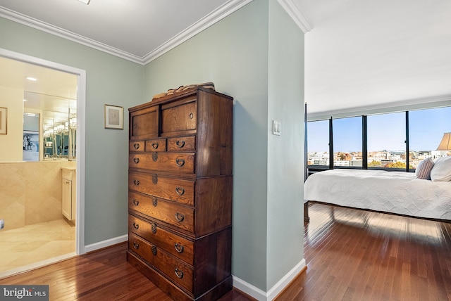 bedroom featuring ensuite bathroom, dark hardwood / wood-style floors, and crown molding