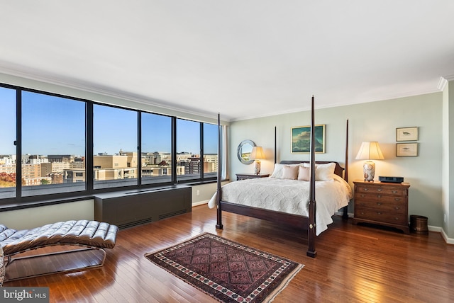 bedroom with wood-type flooring, crown molding, and multiple windows