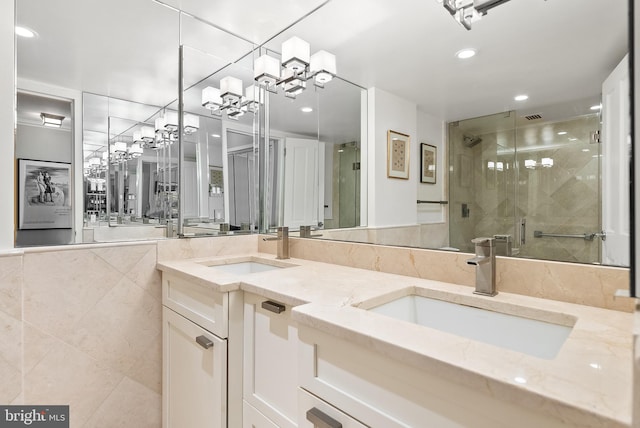 bathroom featuring vanity, an enclosed shower, and tile walls