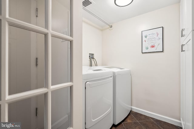 washroom with dark tile patterned flooring and independent washer and dryer