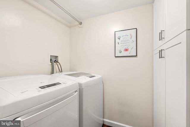 washroom featuring washer and clothes dryer and cabinets