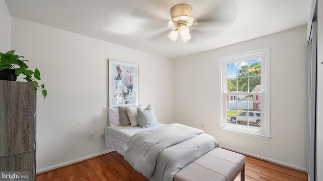 bedroom with wood finished floors, baseboards, and a ceiling fan