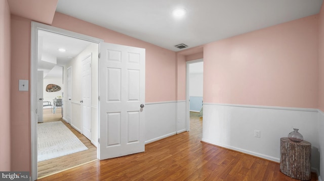hall with wood finished floors, baseboards, and recessed lighting