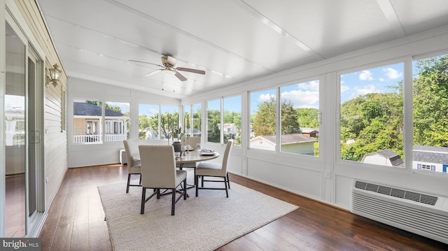 sunroom / solarium with vaulted ceiling, ceiling fan, wood finished floors, and a wall mounted AC