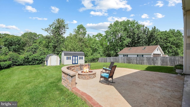 view of patio / terrace featuring a shed, a fire pit, and an outbuilding