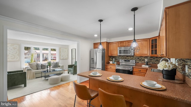 kitchen with stainless steel appliances, brown cabinets, a peninsula, glass insert cabinets, and open floor plan