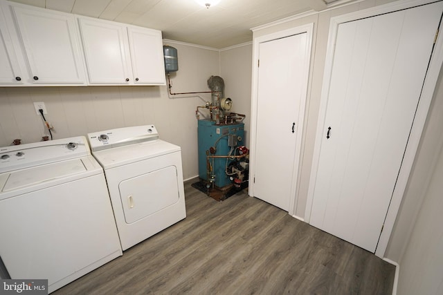 laundry area featuring ornamental molding, cabinets, separate washer and dryer, and dark hardwood / wood-style floors