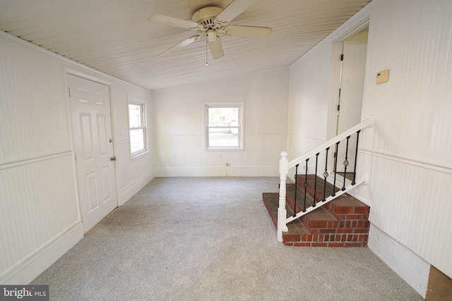 carpeted entryway with ceiling fan and lofted ceiling