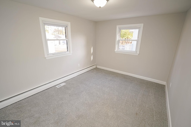 carpeted spare room featuring baseboard heating