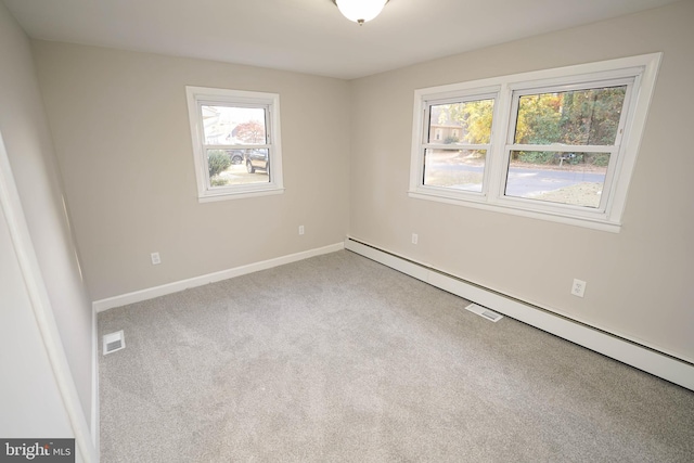 carpeted empty room with a healthy amount of sunlight and baseboard heating