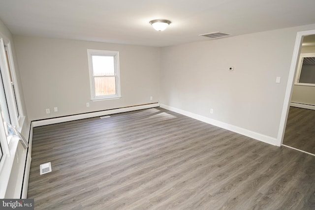 unfurnished room featuring a baseboard radiator and hardwood / wood-style flooring