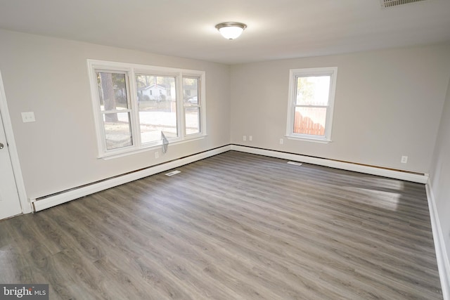 unfurnished room with dark hardwood / wood-style floors and a baseboard radiator