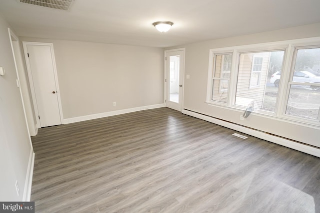 interior space with a baseboard radiator and hardwood / wood-style floors