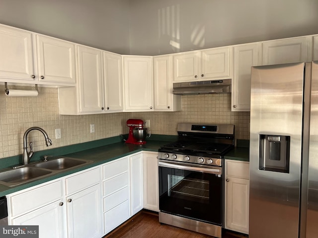 kitchen featuring appliances with stainless steel finishes, sink, backsplash, dark hardwood / wood-style flooring, and white cabinets