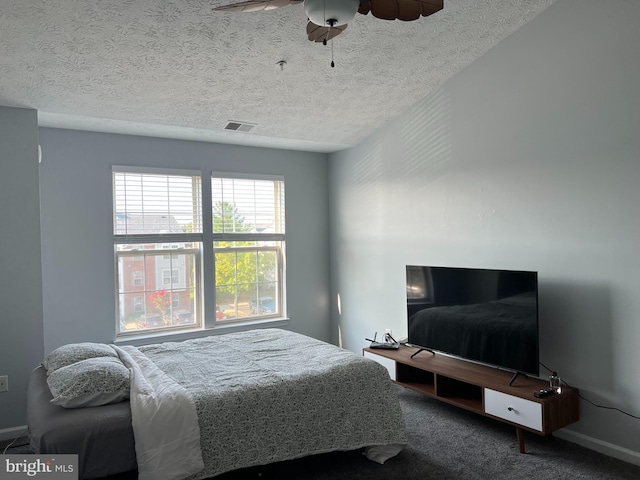 bedroom with a textured ceiling, carpet floors, and ceiling fan