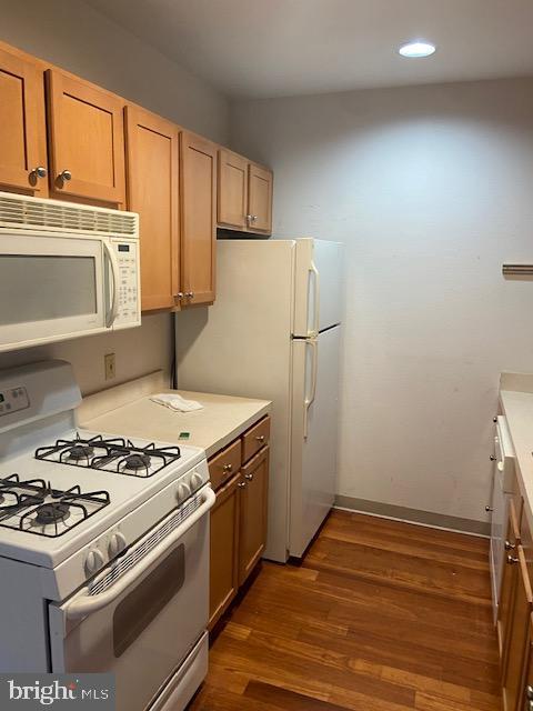 kitchen featuring dark hardwood / wood-style flooring and white appliances