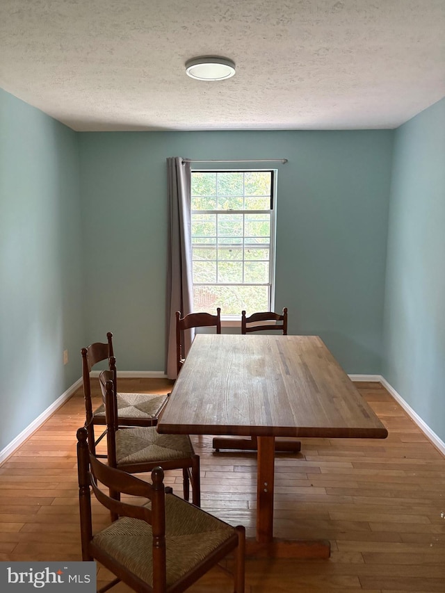 dining space with a textured ceiling and wood-type flooring