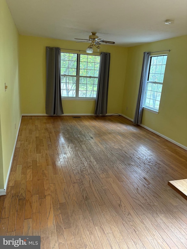 unfurnished room with hardwood / wood-style flooring and ceiling fan