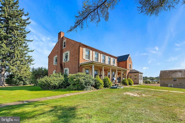 133 Sprecher Rd, Willow Street, PA 17584 - view of front of property with covered porch, brick siding, a front lawn, and a chimney