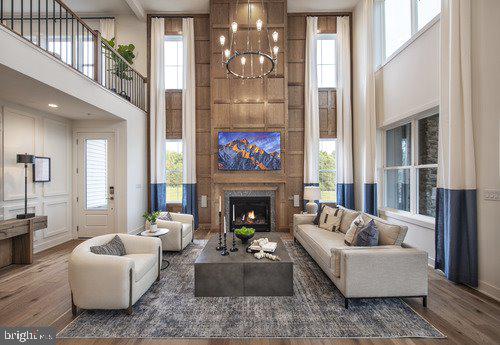 living room with a healthy amount of sunlight, dark hardwood / wood-style flooring, and a high ceiling