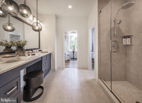 bathroom with vanity, a shower with shower door, and tile patterned floors