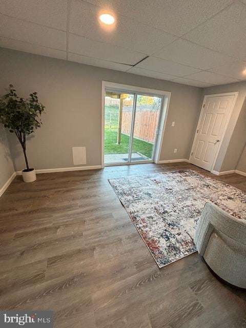 interior space featuring a paneled ceiling and hardwood / wood-style flooring