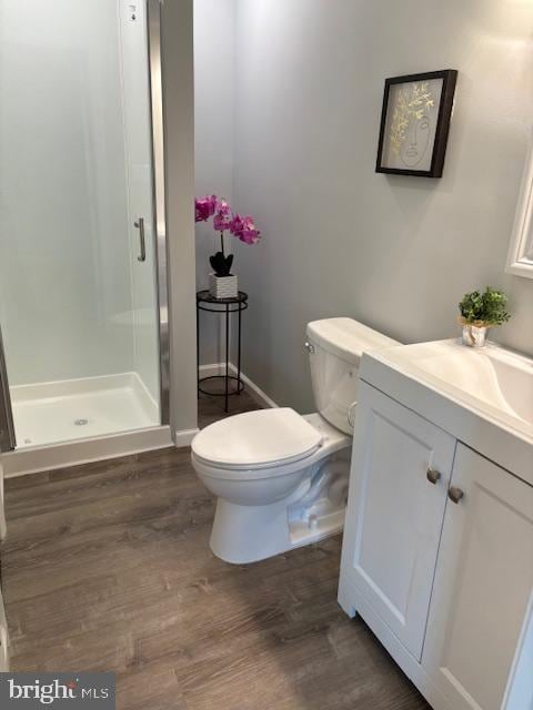 bathroom with vanity, toilet, walk in shower, and wood-type flooring