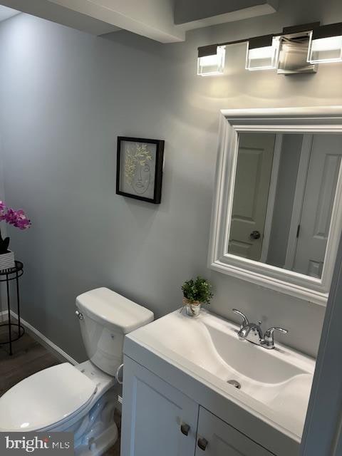 bathroom with vanity, wood-type flooring, and toilet