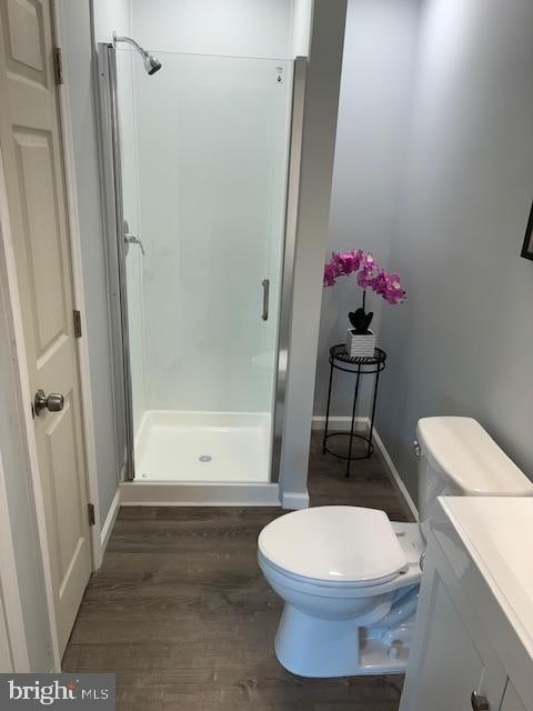 bathroom with vanity, a shower, wood-type flooring, and toilet