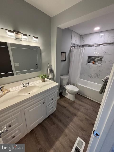 full bathroom with vanity, hardwood / wood-style floors, shower / tub combo with curtain, and toilet