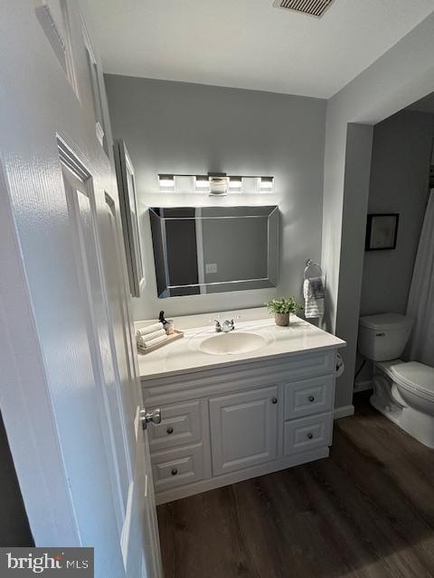 bathroom with vanity, toilet, and wood-type flooring