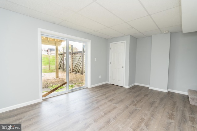 unfurnished room featuring wood-type flooring and a paneled ceiling