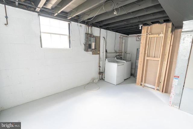 basement with electric panel and washing machine and clothes dryer