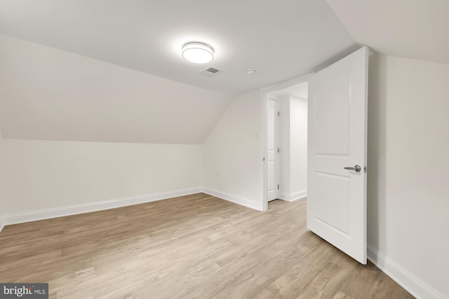 bonus room with vaulted ceiling and light wood-type flooring