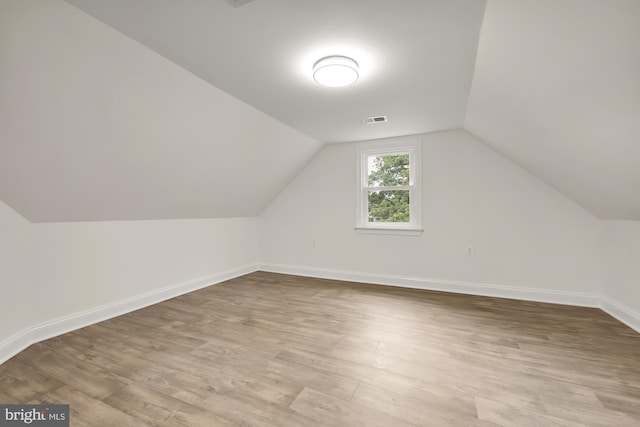 bonus room with lofted ceiling and hardwood / wood-style floors